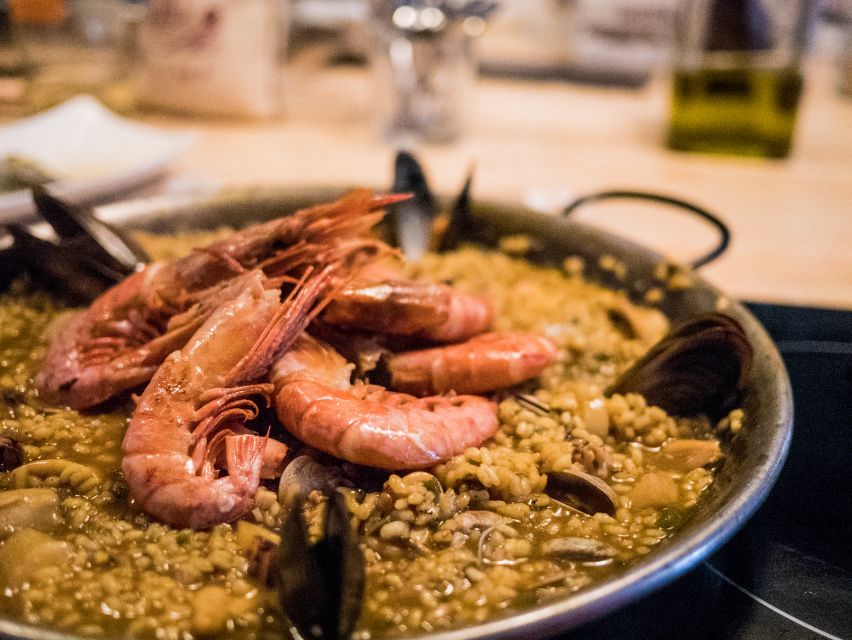 Barcelona: Paella Cooking Workshop and Market Tour - Preparing seafood paella for the table